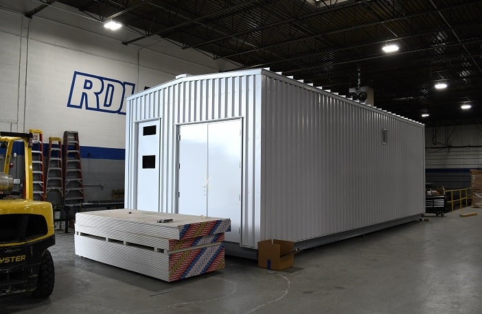 Custom-engineered, prefabricated pump house building with exterior personnel door and pipe chase manufactured at RDI Enclosures' facility.